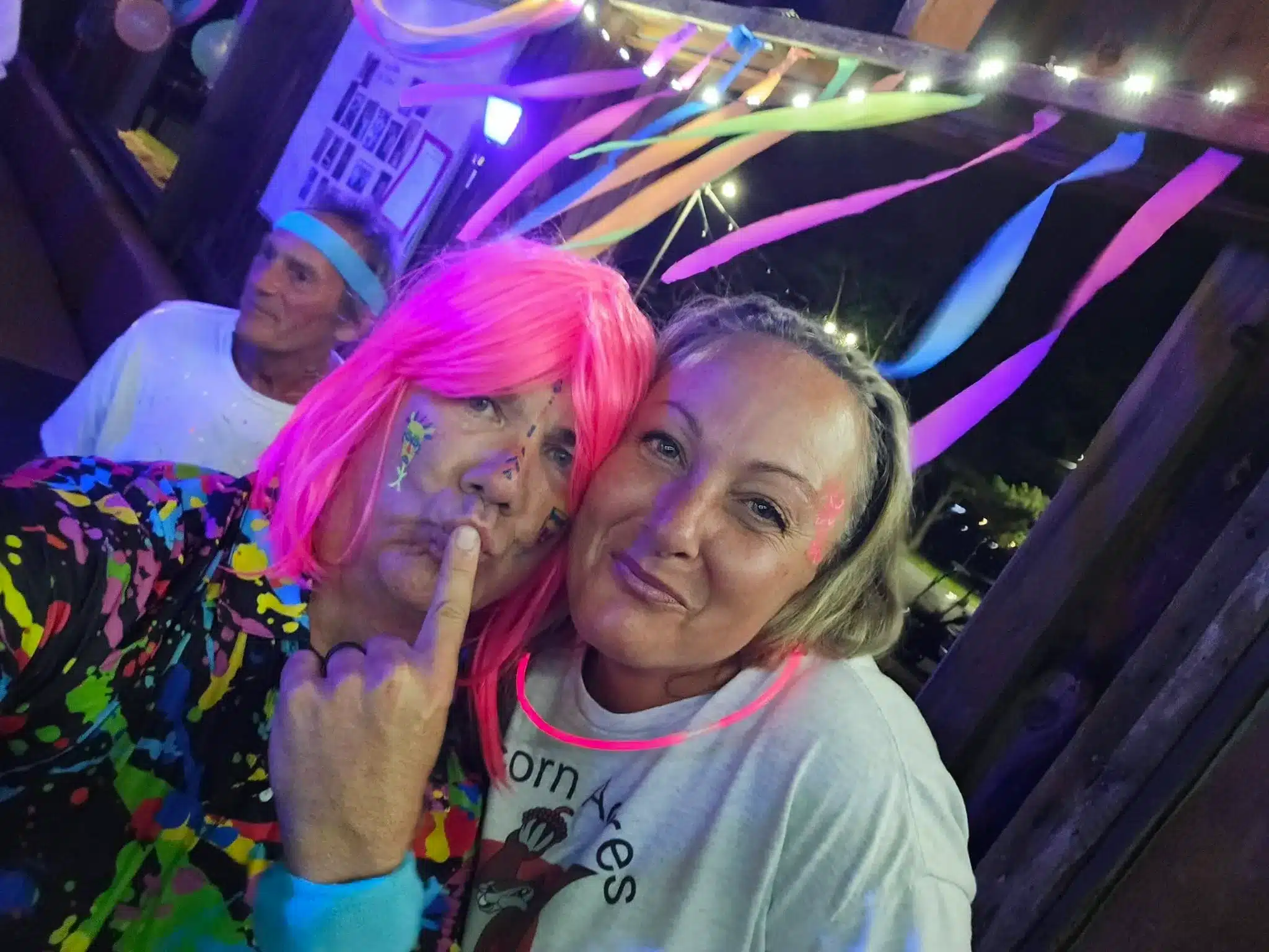 Campers posing in colorful wigs during an Acorn Acres neon weekend party