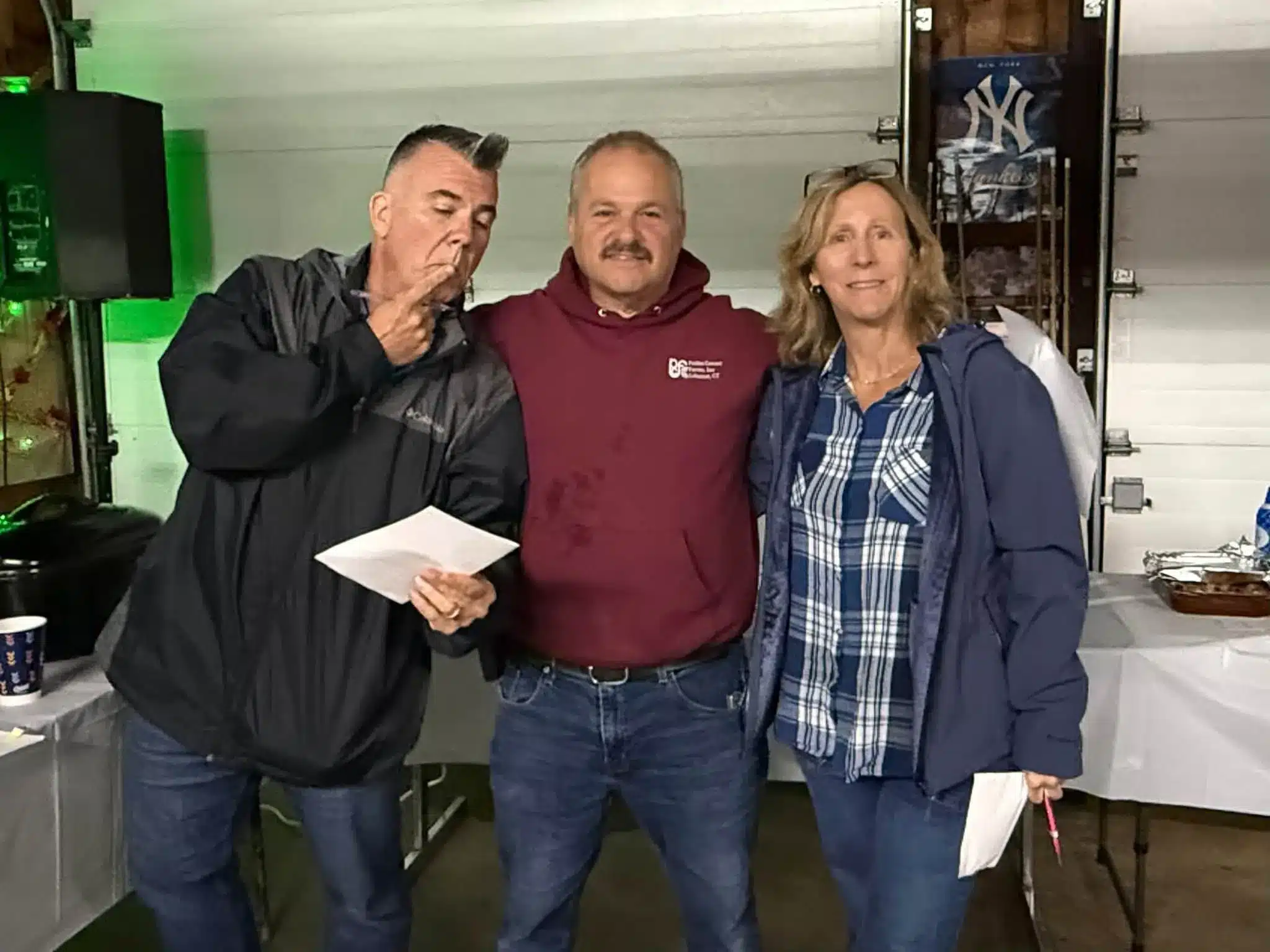 Three adults posing together indoors during a gathering at Acorn Acres Campground in Bozrah, CT