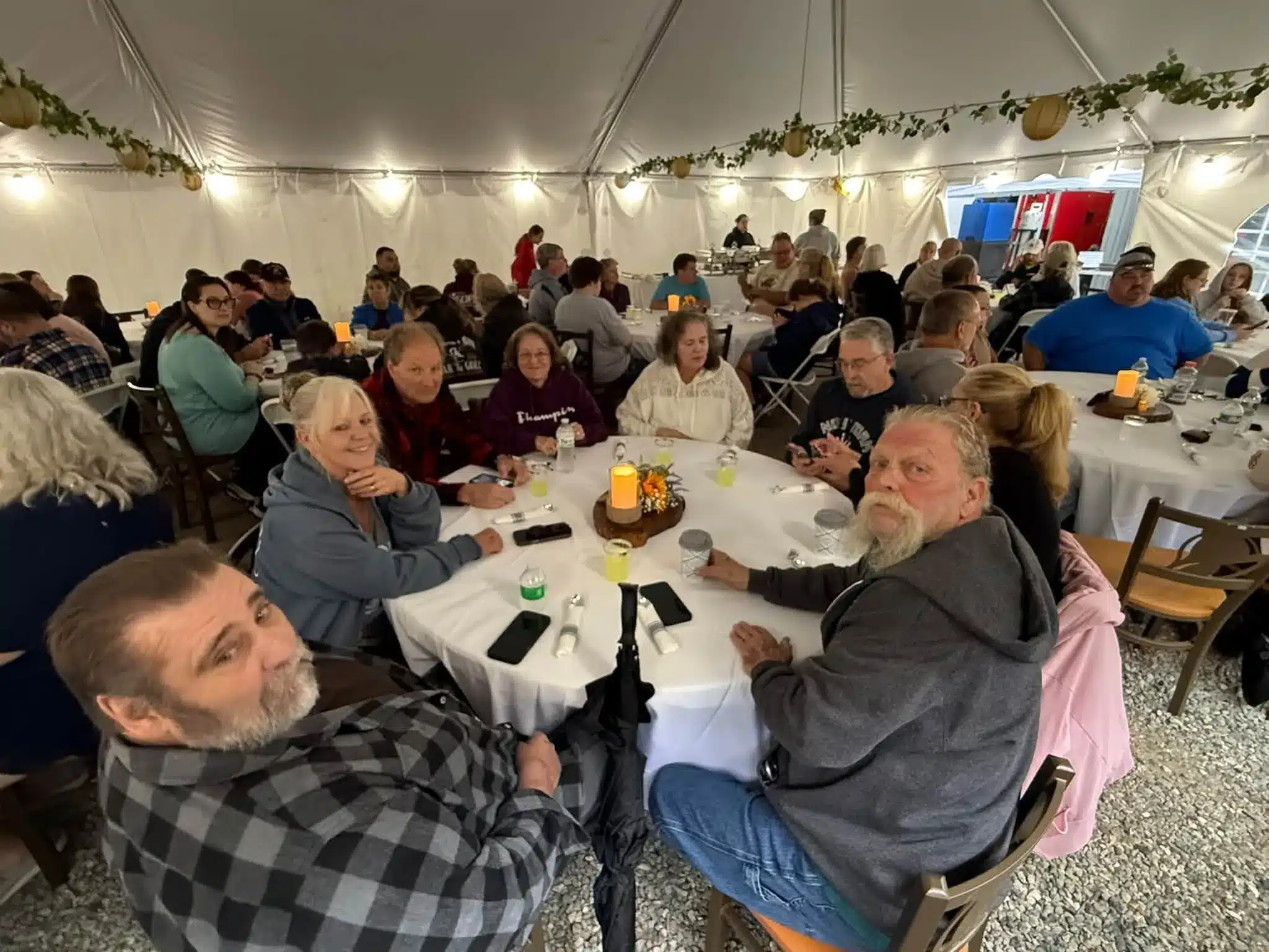 Large group seated around a decorated dining table during a gathering at Acorn Acres Campground in Bozrah, CT